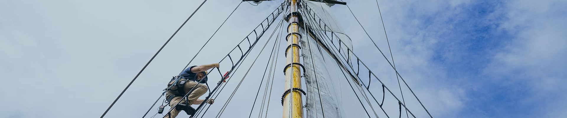 man climbing sail