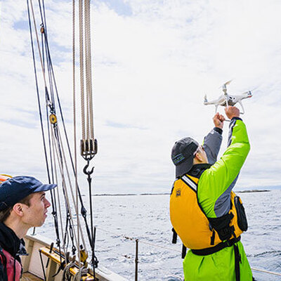 man catching drone on ship
